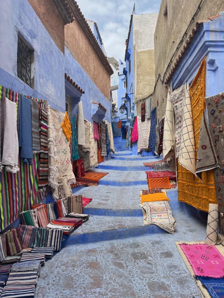 rugs lining a blue street in chefchaouen morocco