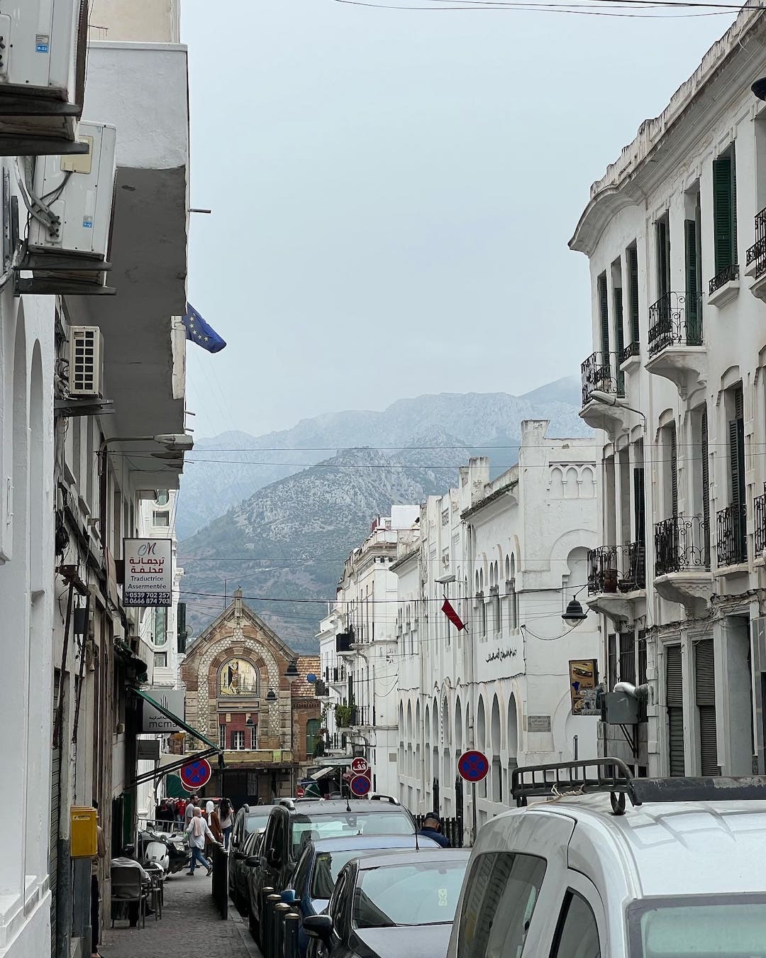 view of a street in tetouan morocco with mountains behind