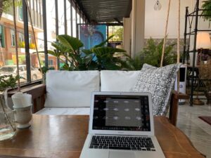 laptop sitting on a table at a cafe with lots of plants
